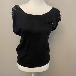 Elegant Black Women's Top with metal
Embellishments flirty back 
Front pocket